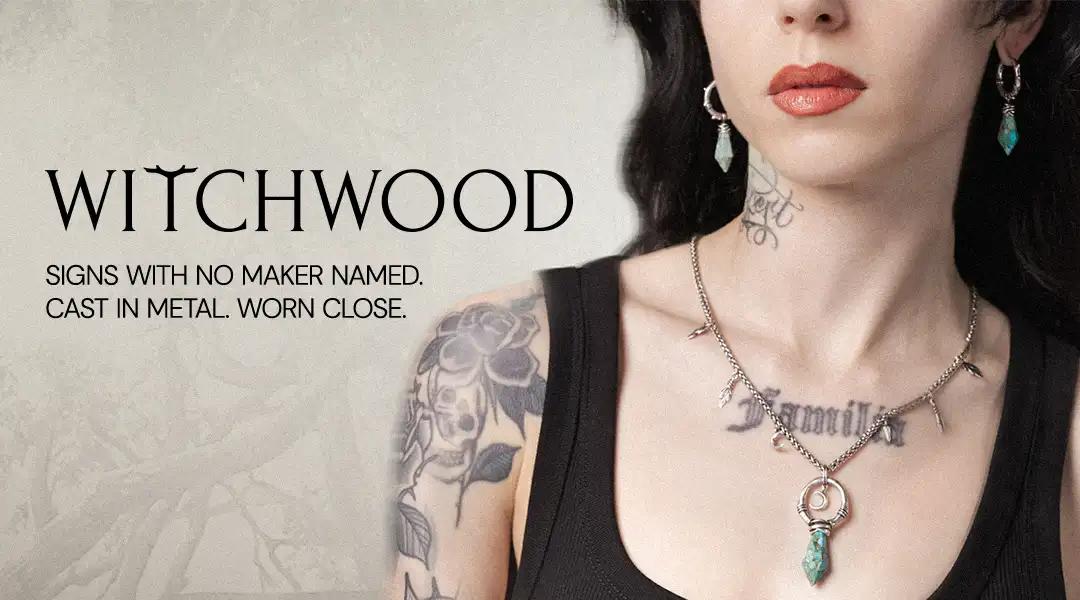 Woman with tattoos and necklaces, featuring the brand 'Witchwood'.