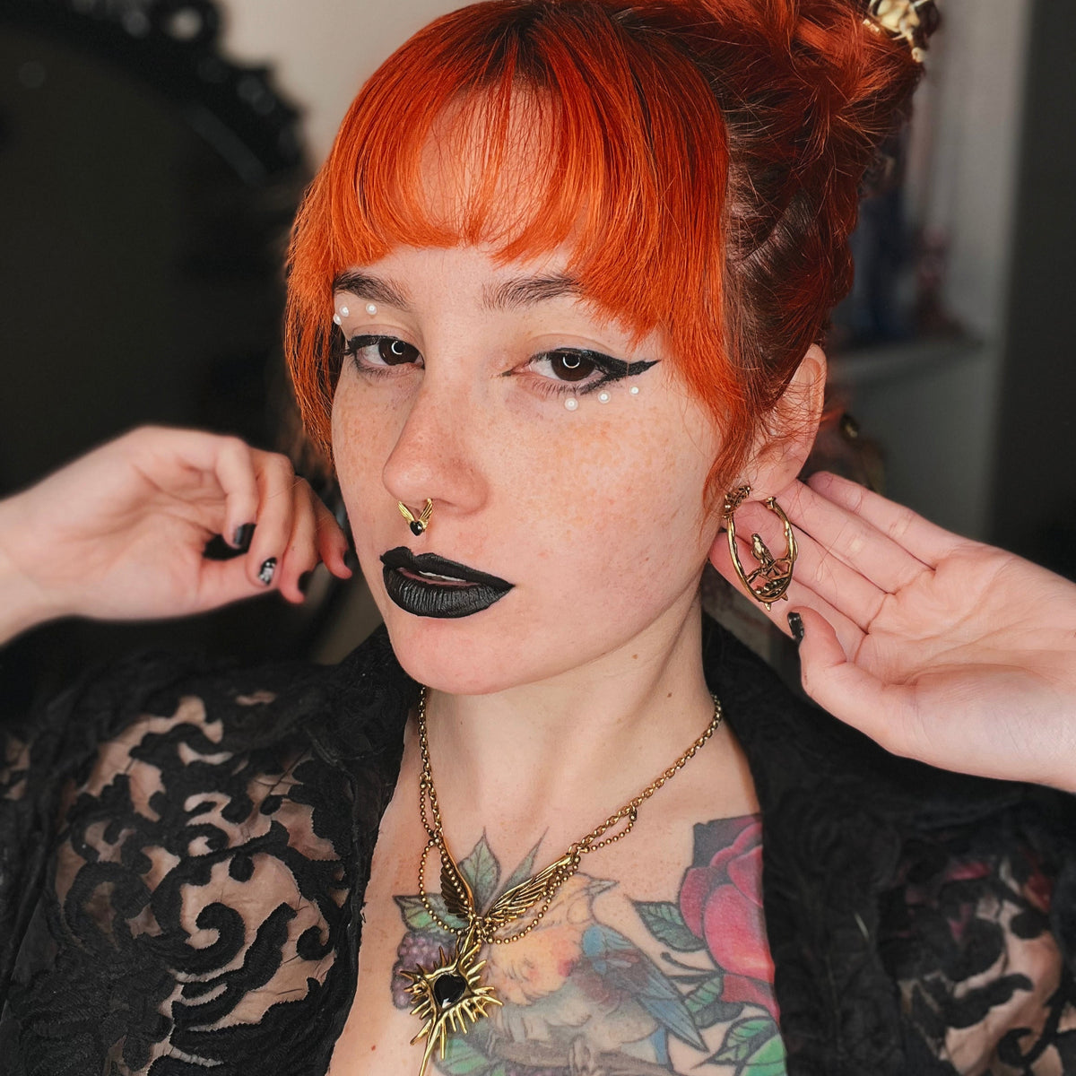 Red-haired model wearing a gold Rosebird hoop earring and matching necklace