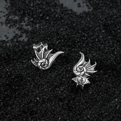 Silver Abyss Conch Ear Studs displayed on black sand, featuring sculpted conch ridges, black zircon centers, and ocean relic styling.