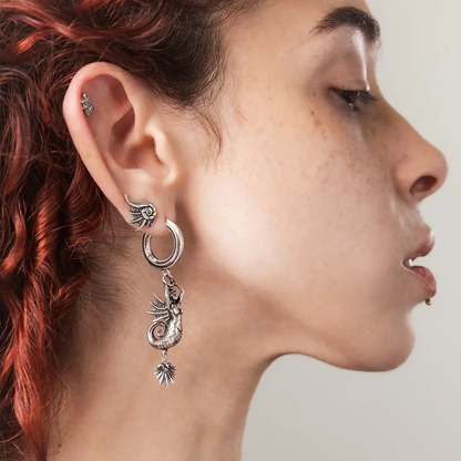 Side view of a model wearing the silver Abyss Conch Ear Studs with dark ocean-inspired styling and layered earrings.