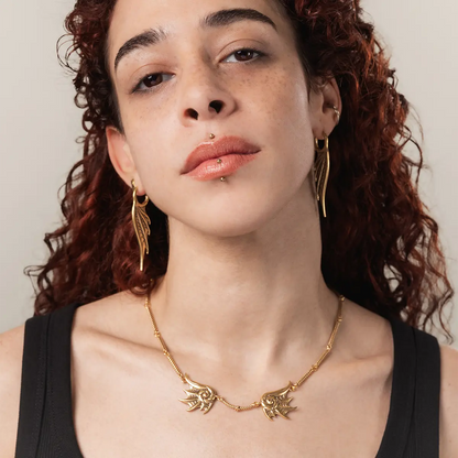 Model wearing the gold Abyssal Bind Necklace with shell-like ridges, a short rope chain center, and dark coastal gothic styling.