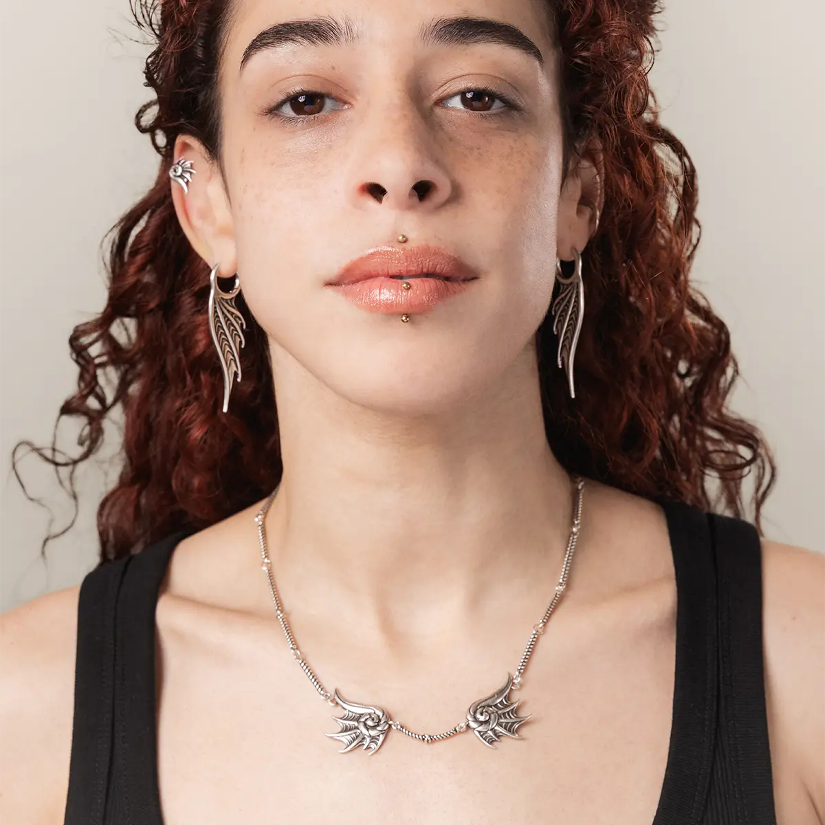 Model wearing the silver Abyssal Bind Necklace, featuring twin conch-like forms, shell ridges, and dark sea-inspired styling.