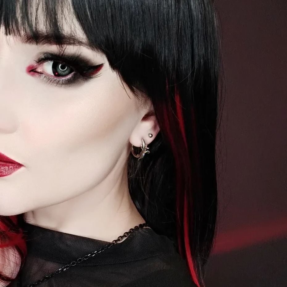 Adaptive Evolution Earrings in 925 sterling silver, worn in a gothic portrait with black hair, red streaks, graphic eyeliner,