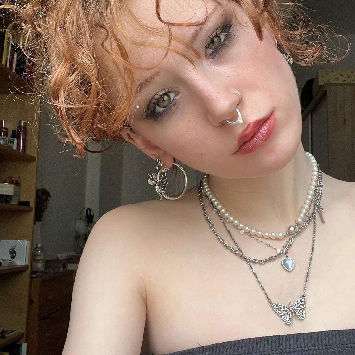 Adaptive Evolution Earrings in 925 sterling silver, worn in a curly-haired selfie with layered pearls, silver chains, and mul