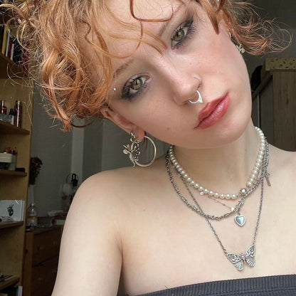 Adaptive Evolution Earrings in 925 sterling silver, worn in a curly-haired selfie with layered pearls, silver chains, and mul