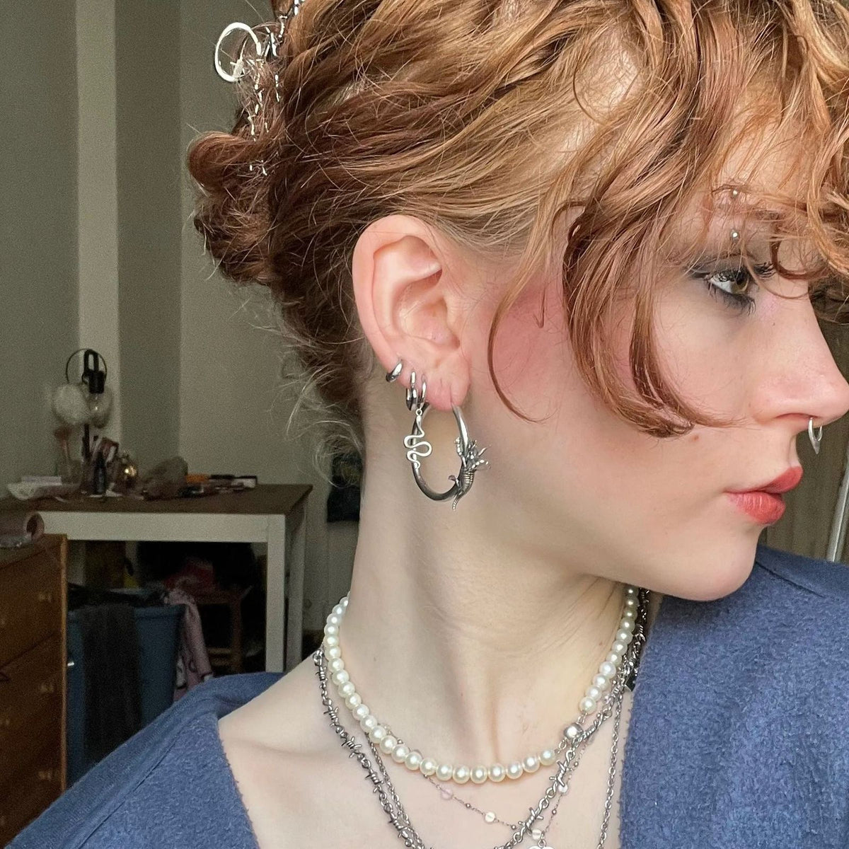 Adaptive Evolution Earrings in 925 sterling silver, worn in side profile with a curly updo, pearl layers, and a mixed silver 