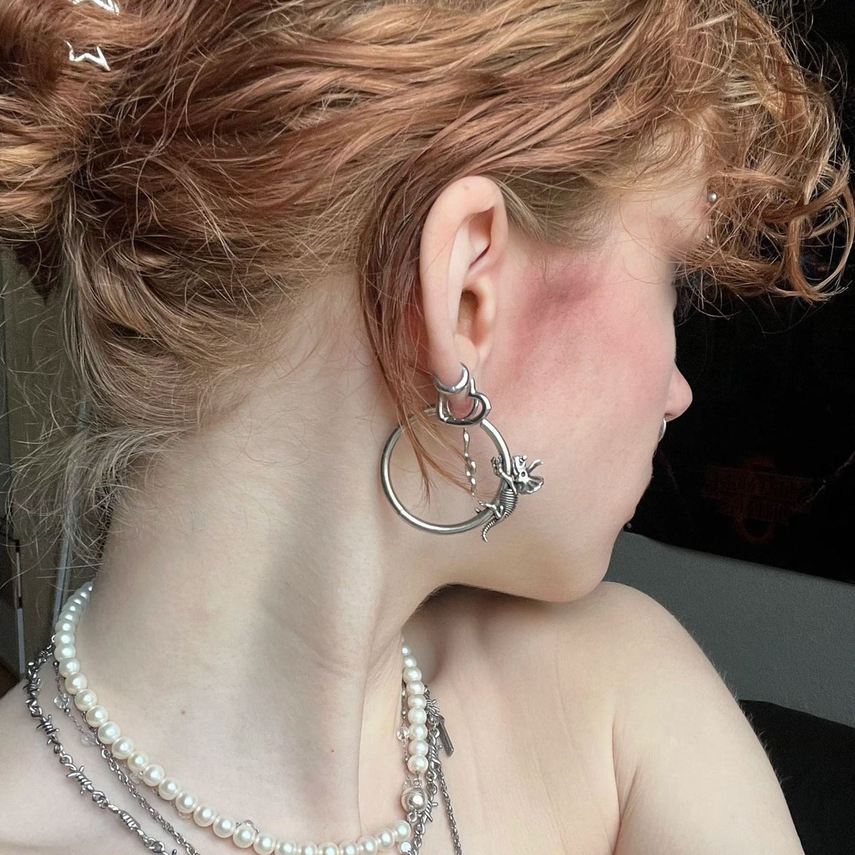 Adaptive Evolution Earrings in 925 sterling silver, styled in a curly updo ear stack with a larger hoop, pearl necklaces, and