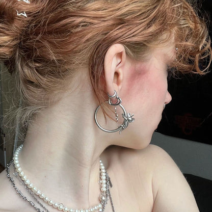 Adaptive Evolution Earrings in 925 sterling silver, styled in a curly updo ear stack with a larger hoop, pearl necklaces, and