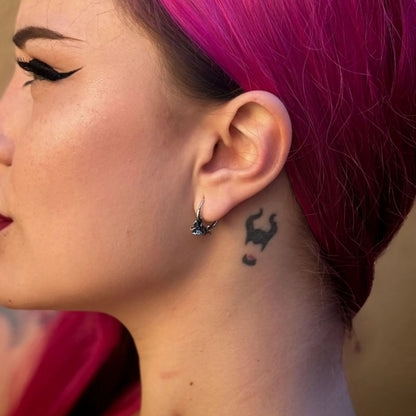 Adaptive Evolution Earrings in 925 sterling silver, worn in a magenta-haired side portrait with winged eyeliner and a black n