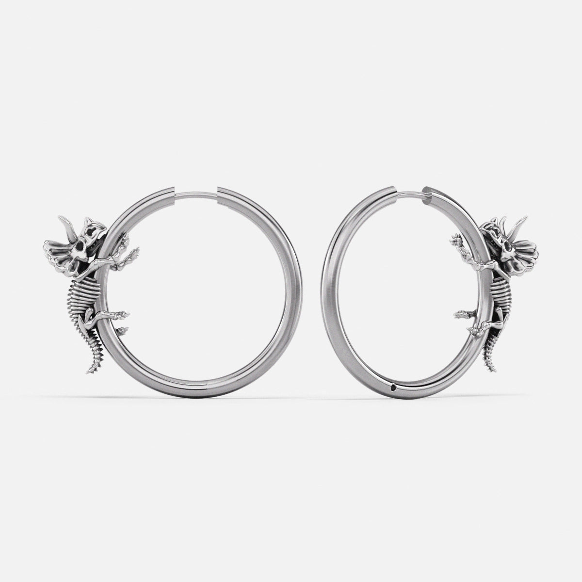 Pair of silver Adaptive Evolution hoop earrings with small creature details