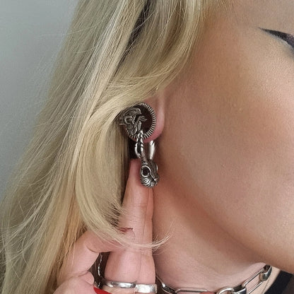 Close-up of an alien invasion tunnel worn in the ear, showing ridged edge and creature design