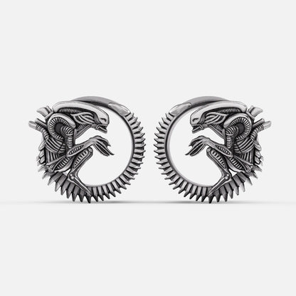Pair of silver-tone alien invasion tunnels with ridged spine detail and coiled creature motif, front view