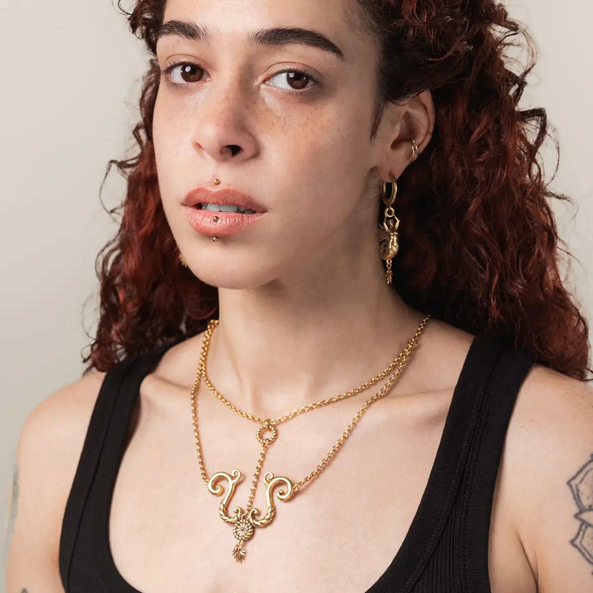 Alternative fashion layered ocean relic necklace in gold finish on model close up