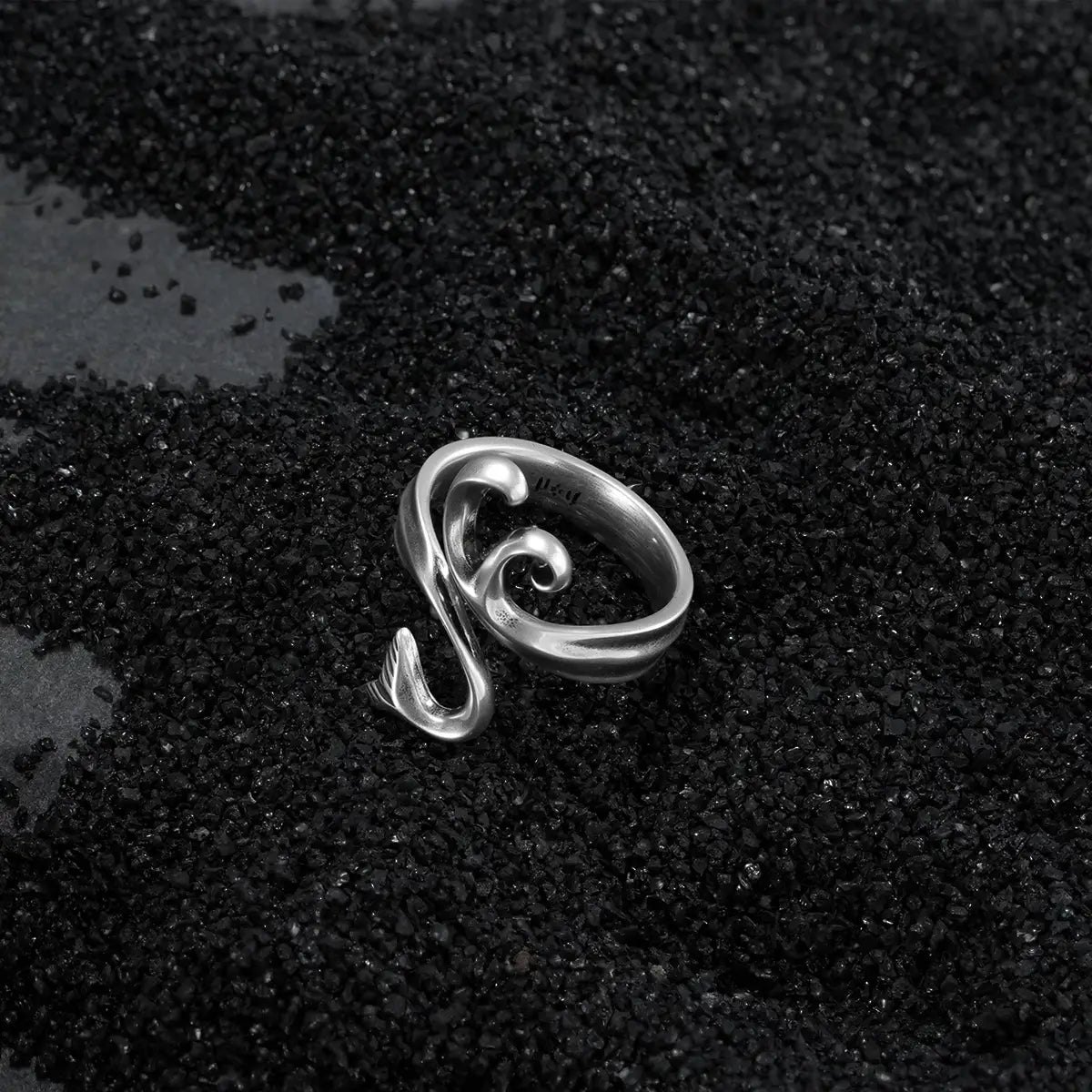 Alternative fashion silver wave ring with antiqued finish on dark coastal black sand