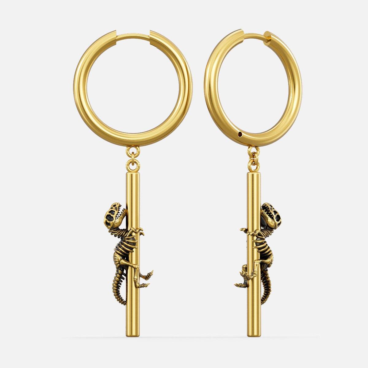 Gold-tone hoop earrings with a dangling dinosaur skeleton charm climbing a bar, shown as a pair