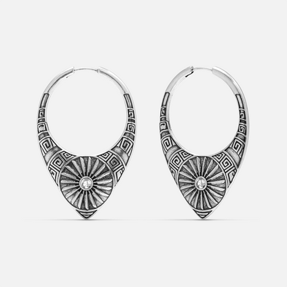 Pair of oxidized silver-tone hoop earrings with sunburst medallion and geometric border, clear stone center