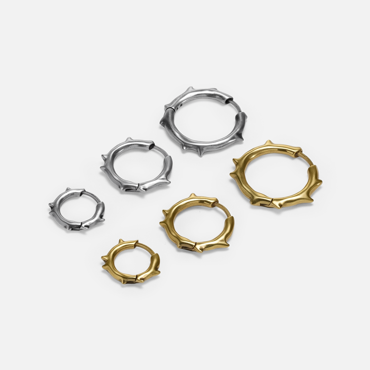 Ancient Thorn Hoops shown in silver and gold tones with multiple hoop size options