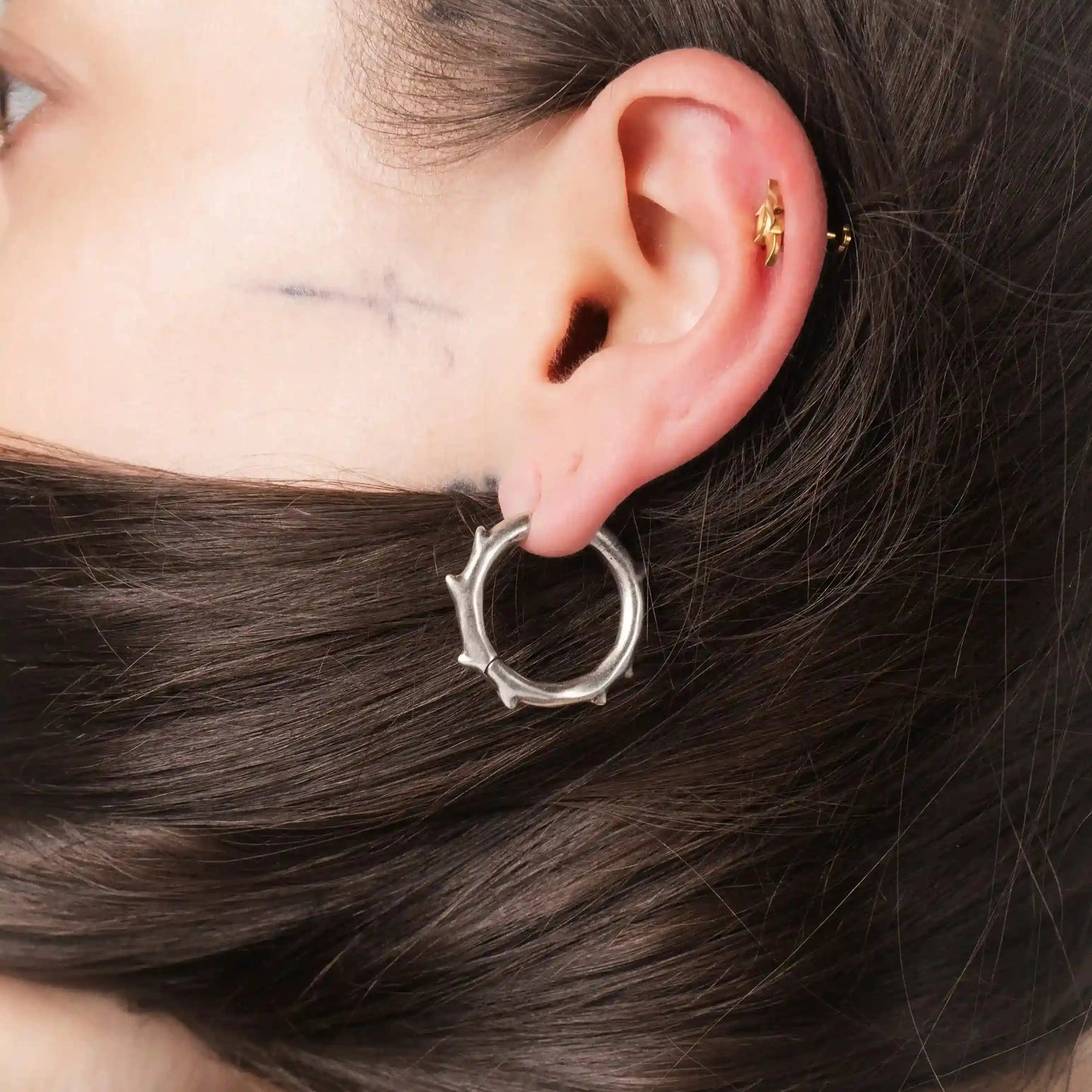 Model wearing silver Ancient Thorn Hoops with gothic thorn-inspired hoop design
