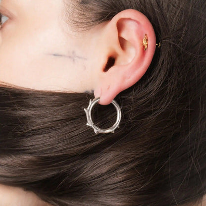 Model wearing silver Ancient Thorn Hoops with gothic thorn-inspired hoop design