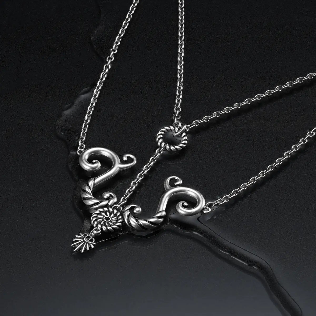 Antiqued silver sea relic knot necklace on dark reflective background