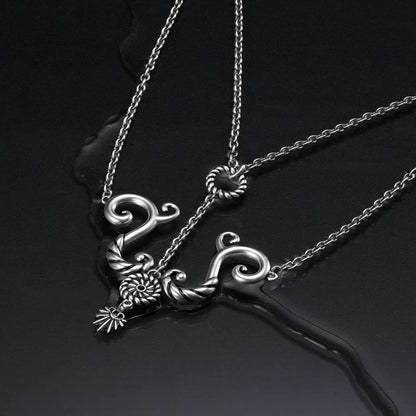 Antiqued silver sea relic knot necklace on dark reflective background