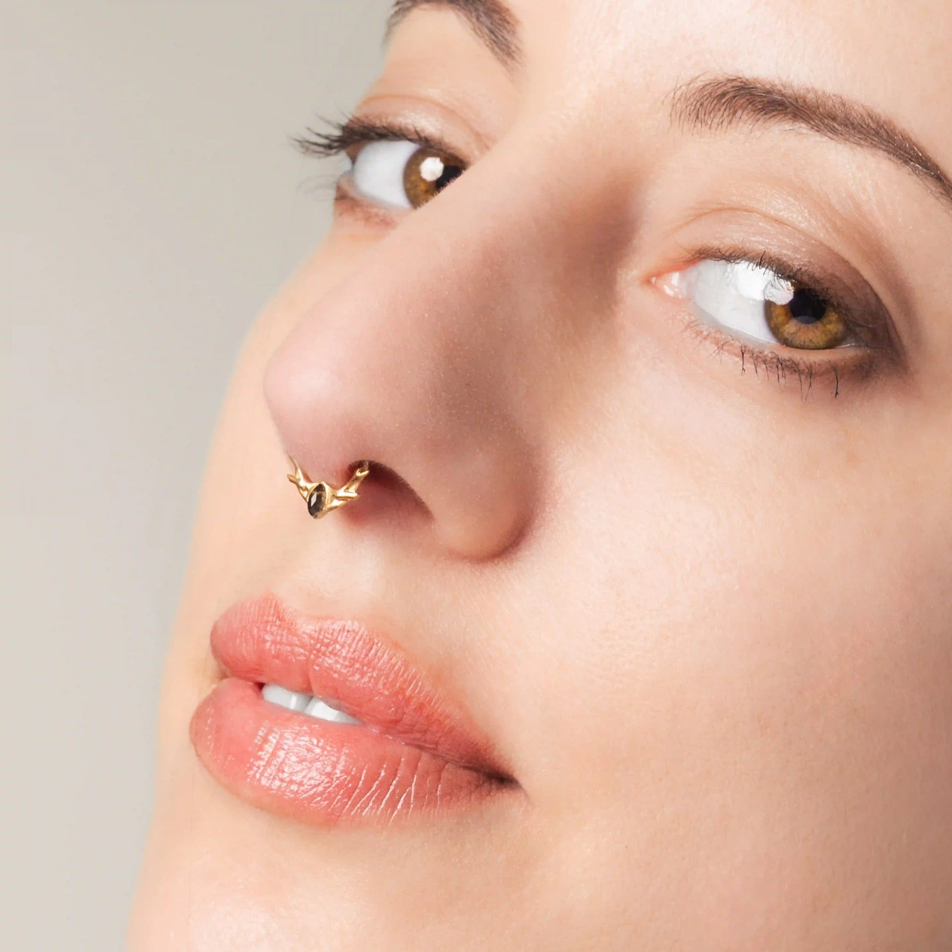 Model wearing gold Antler Mark Clicker with black obsidian and woodland antler styling