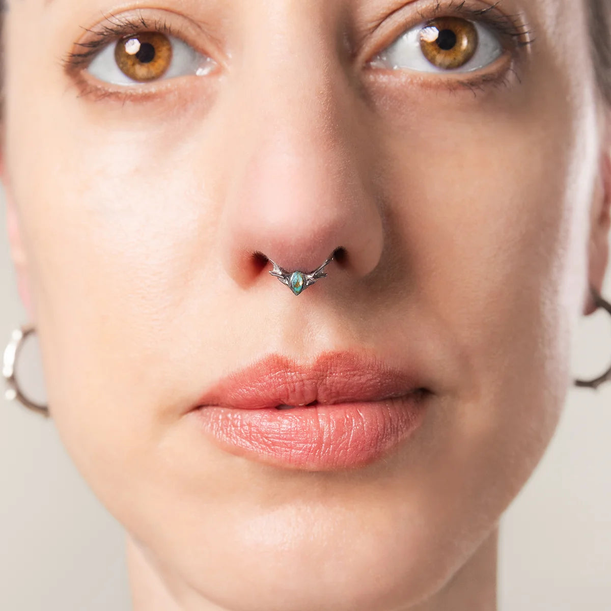 Model wearing silver Antler Mark Clicker with turquoise stone and antler-inspired septum design