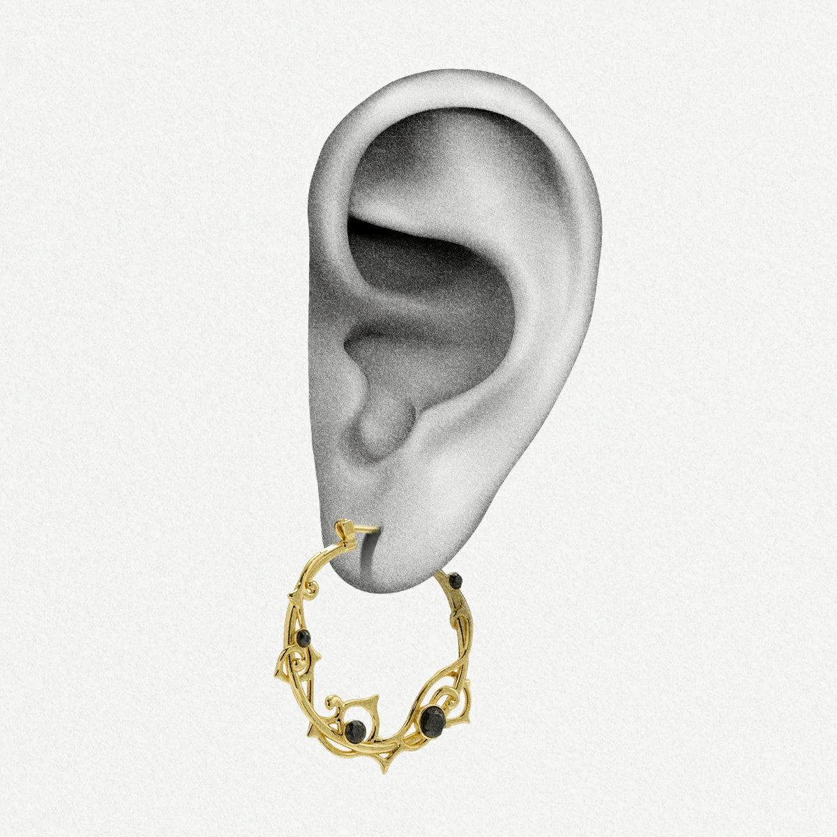 Gold Arcane Vine hoop earring shown on an ear illustration