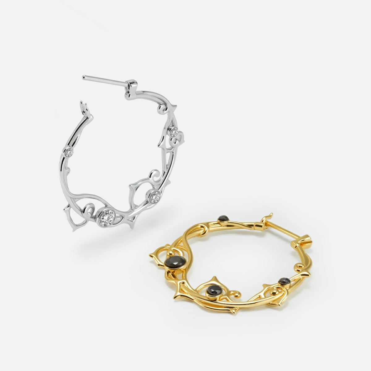 Silver and gold Arcane Vine hoop earrings shown open and lying flat