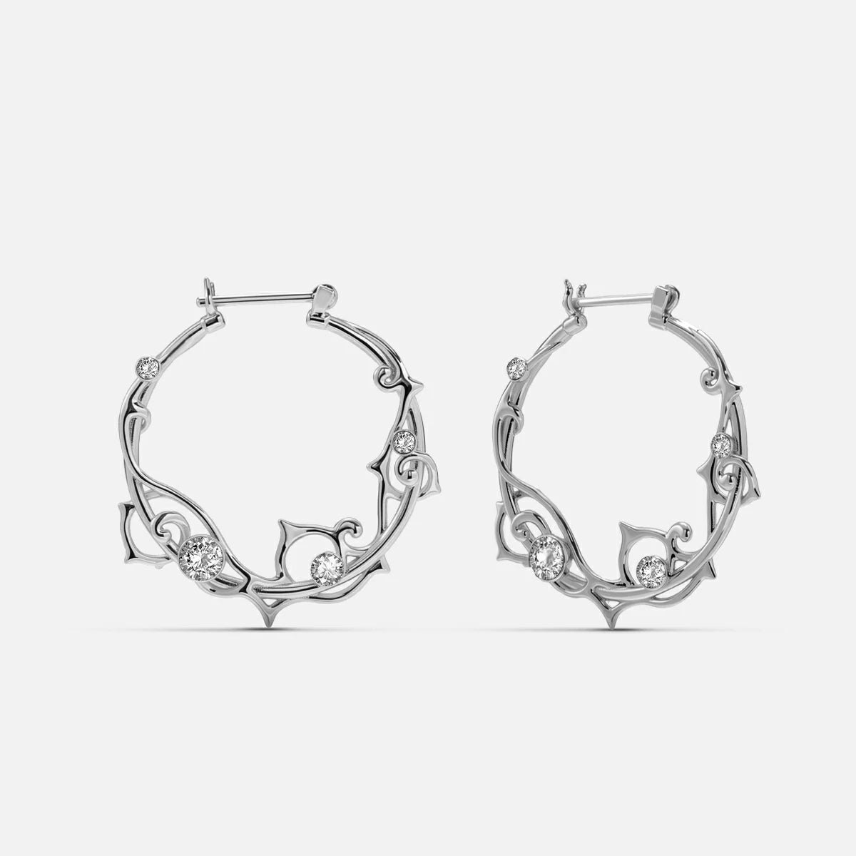 Pair of silver-tone vine hoop earrings with clear stone accents on a plain background
