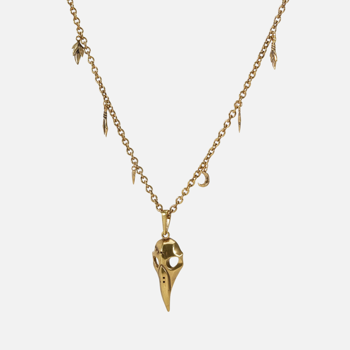 Gold Augur Skull Necklace with bird skull pendant, crescent charm, and leaf detail chain