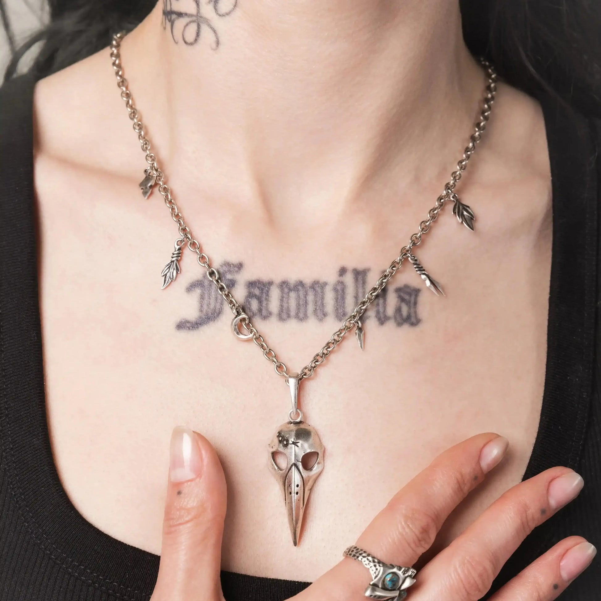 Model wearing the silver Augur Skull Necklace with bird skull pendant and charm chain