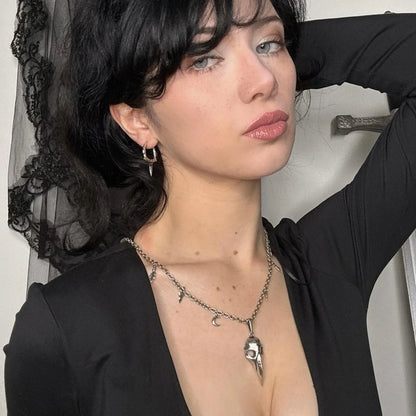 Model wearing the silver Augur Skull Necklace with bird skull pendant, leaf charms, curb chain, and dark gothic styling.