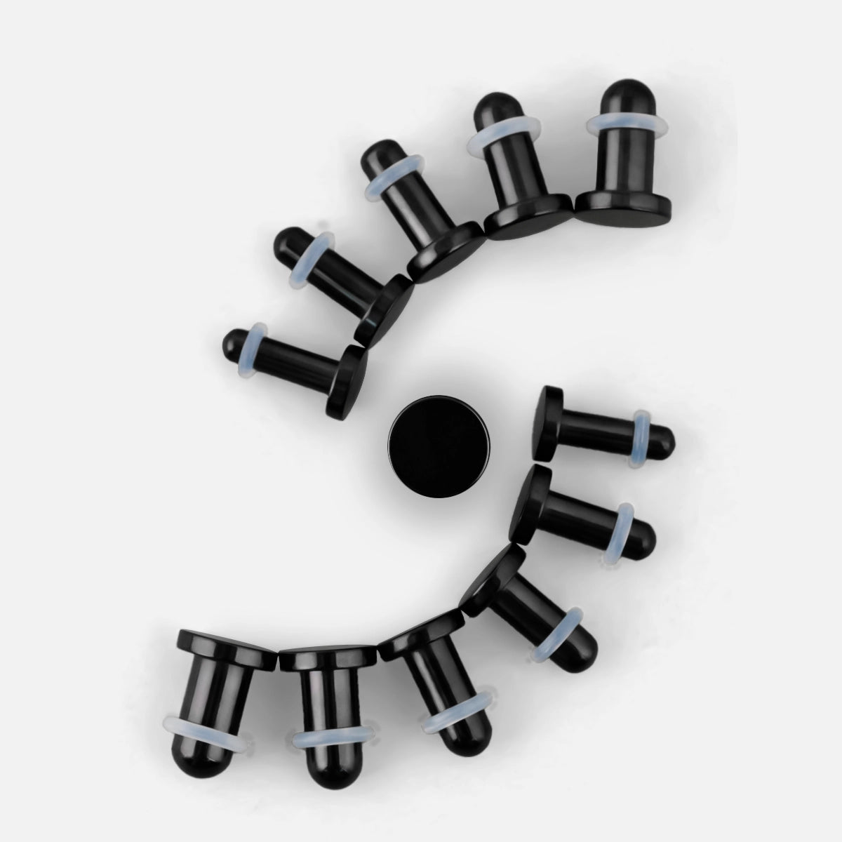 Black Aurora ear stretching plugs arranged in a curved size progression on a white background