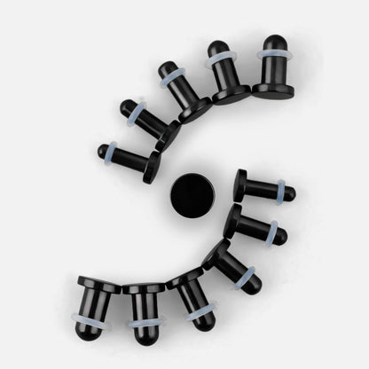 Black Aurora ear stretching plugs arranged in a curved size progression on a white background