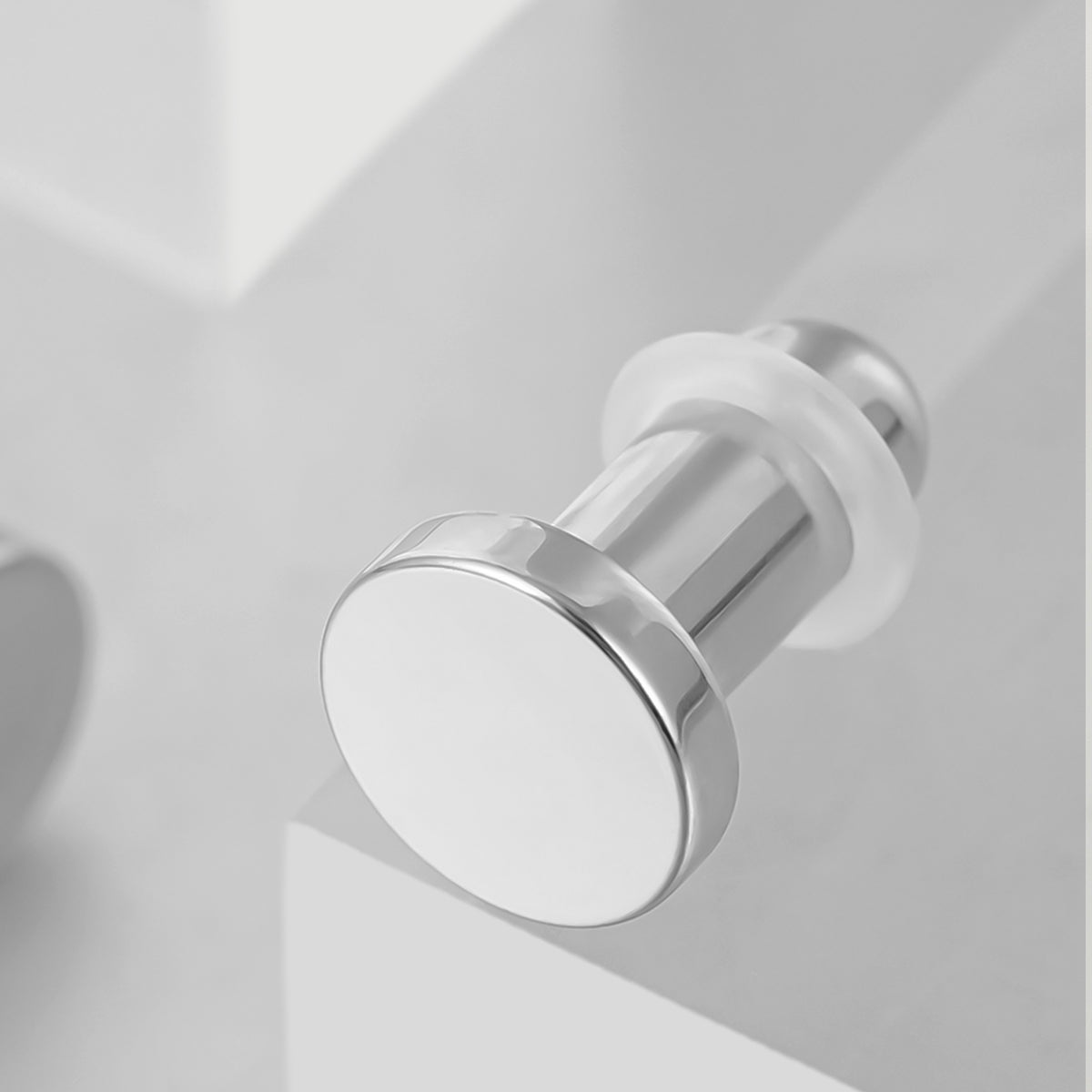 Silver Aurora solid ear plug shown at an angle with a flat circular face and flared rim
