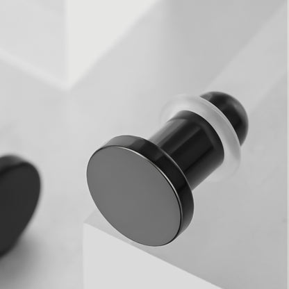 Black Aurora solid ear plug shown at an angle with a flat circular face and flared rim