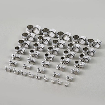 Full set of steel ear stretching plugs and tunnels arranged in graduated sizes on a flat surface