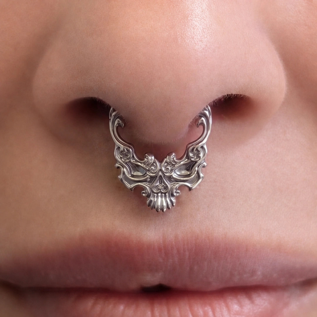 Silver-tone Baroque Skull Clicker worn as a septum ring, featuring an elaborate gothic skull design.