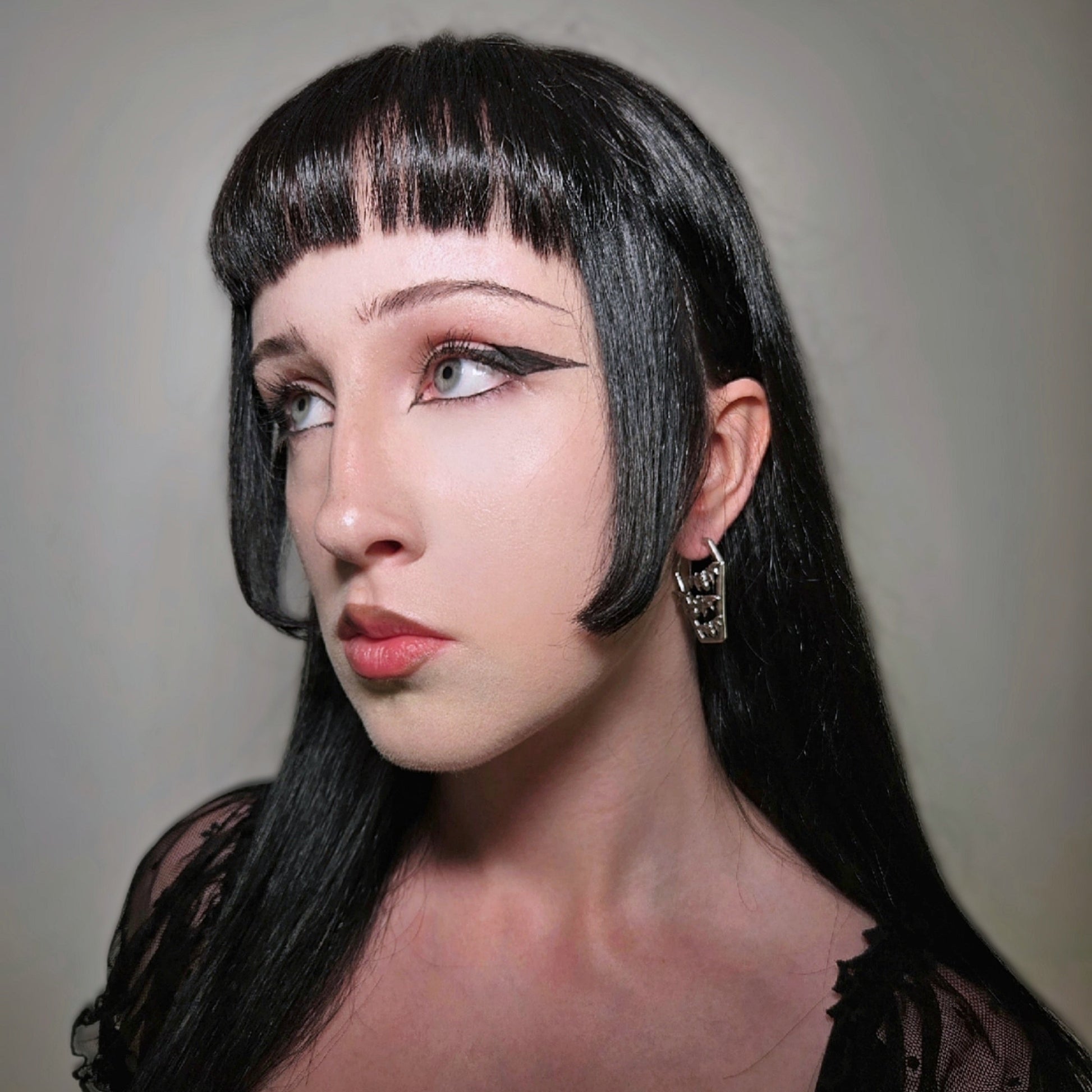 Model wearing a silver Bat Tomb coffin hoop earring