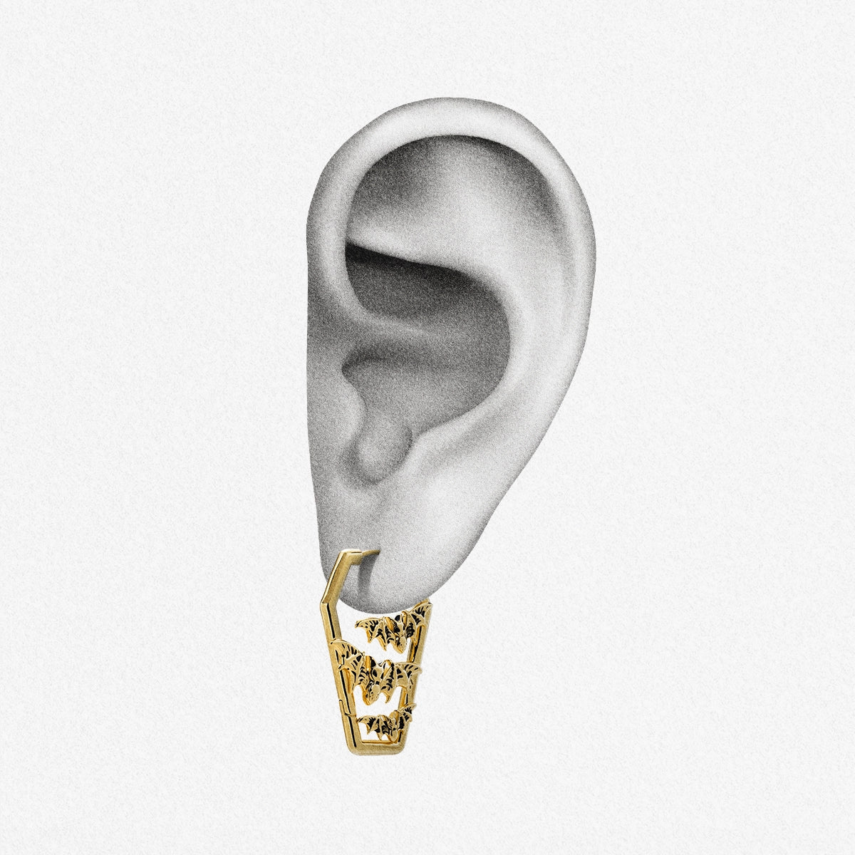 Gold Bat Tomb coffin hoop earring shown on an ear illustration