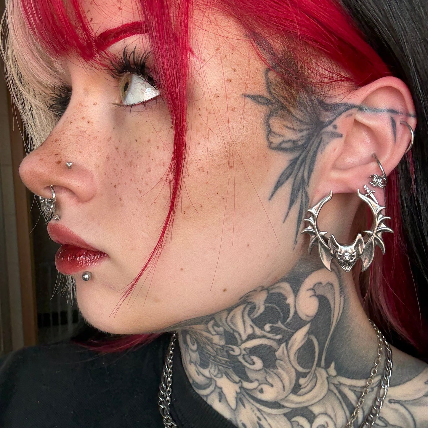 Side view of red-haired model wearing a silver Bat Whisper tunnel