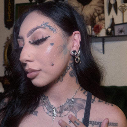 Model wearing a small silver Bat Whisper tunnel in a stretched lobe