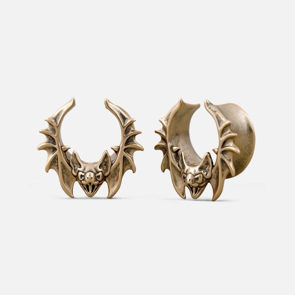 Pair of gold Bat Whisper tunnels with sculpted bat faces and winged frames