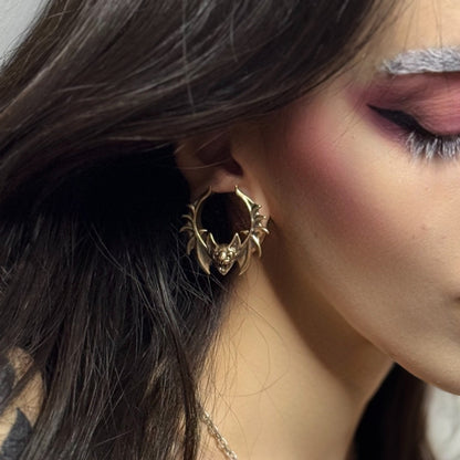 Side view of gold Bat Whisper tunnel worn in a stretched lobe