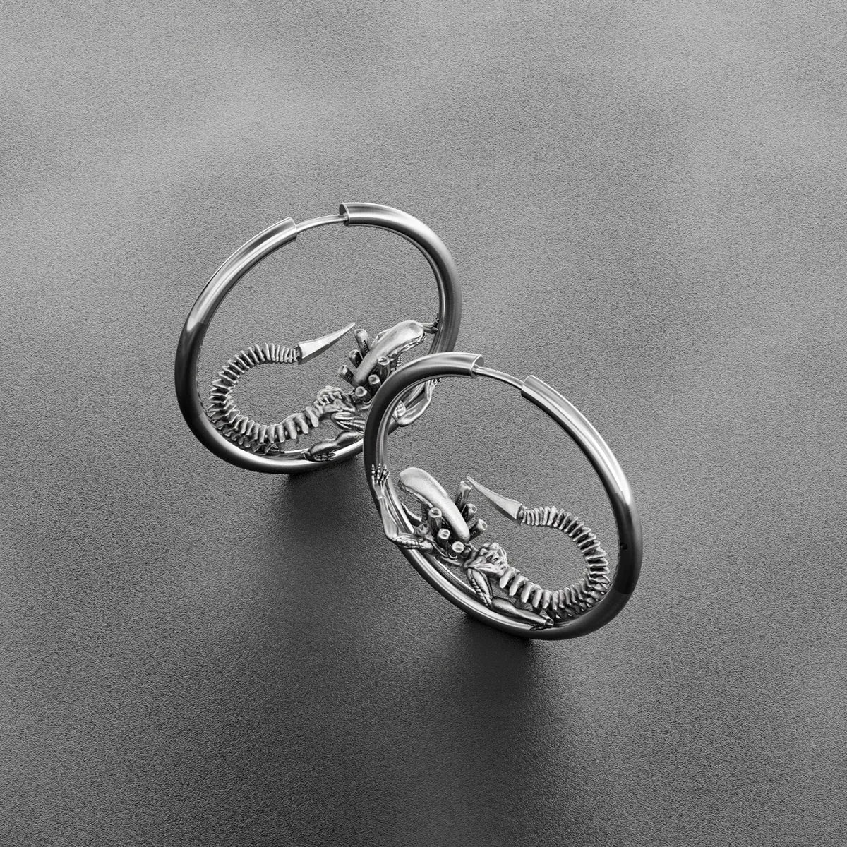 Pair of silver Biomechanical Alien hoop earrings with curled skeletal creature details