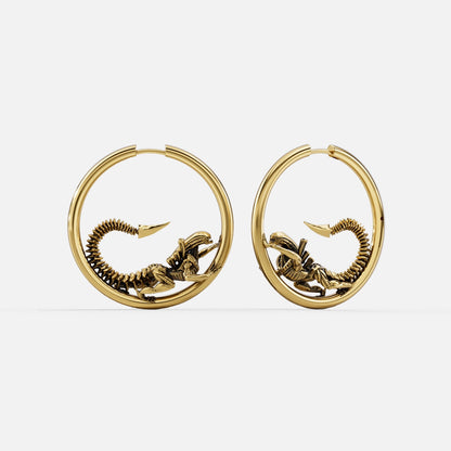 Pair of gold Biomechanical Alien hoop earrings with curled skeletal creature motifs