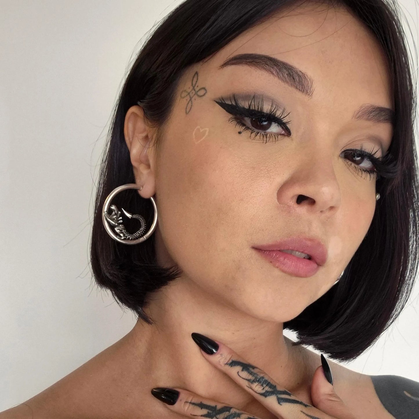 Silver Biomechanical Alien Hoop Earrings styled on model with xenomorph-inspired hoop silhouette and gothic jewelry look