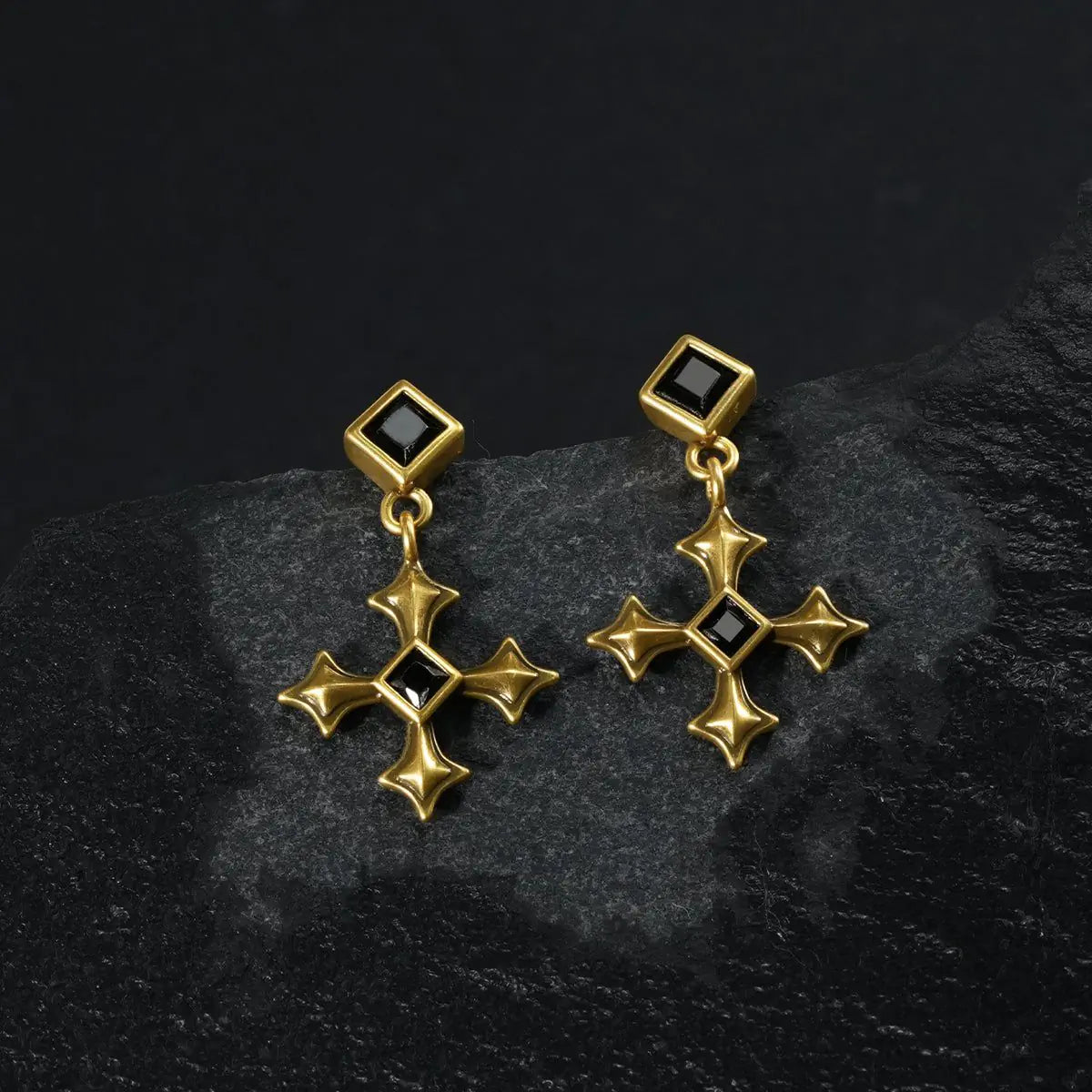 Gold Black Testament Earrings displayed as a pair on black textured fabric.