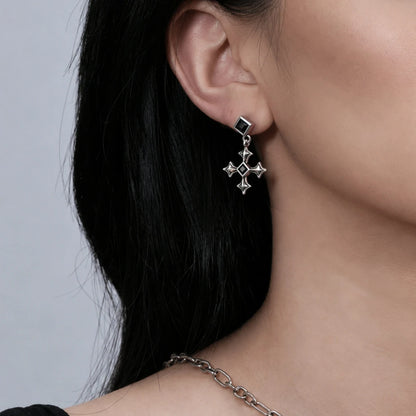 Black Testament Earrings in antiqued silver worn on the ear in a close side-neck view with dark hair swept back.